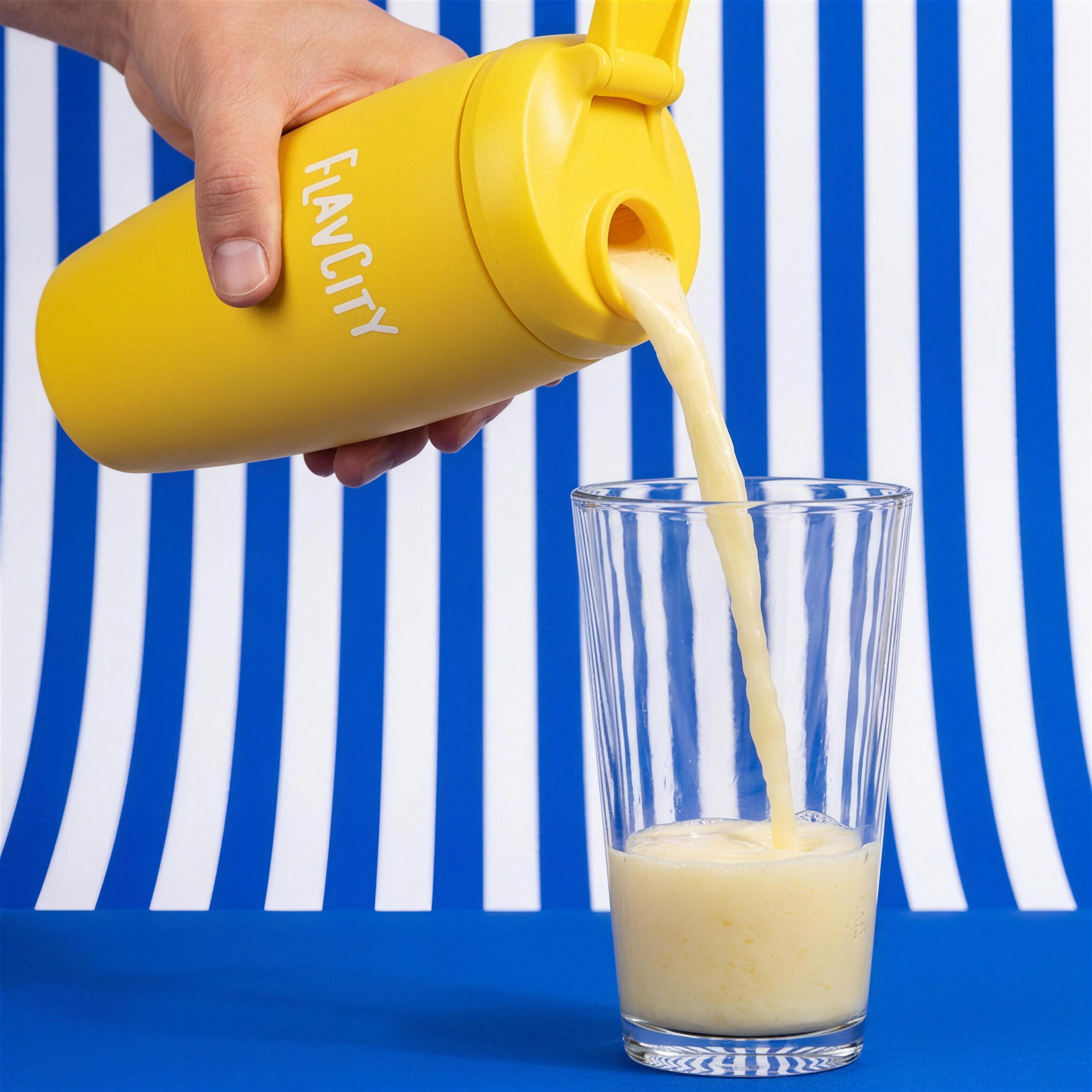 Pouring Whipped Lemonade Protein Smoothie from FlavCity shaker bottle into glass